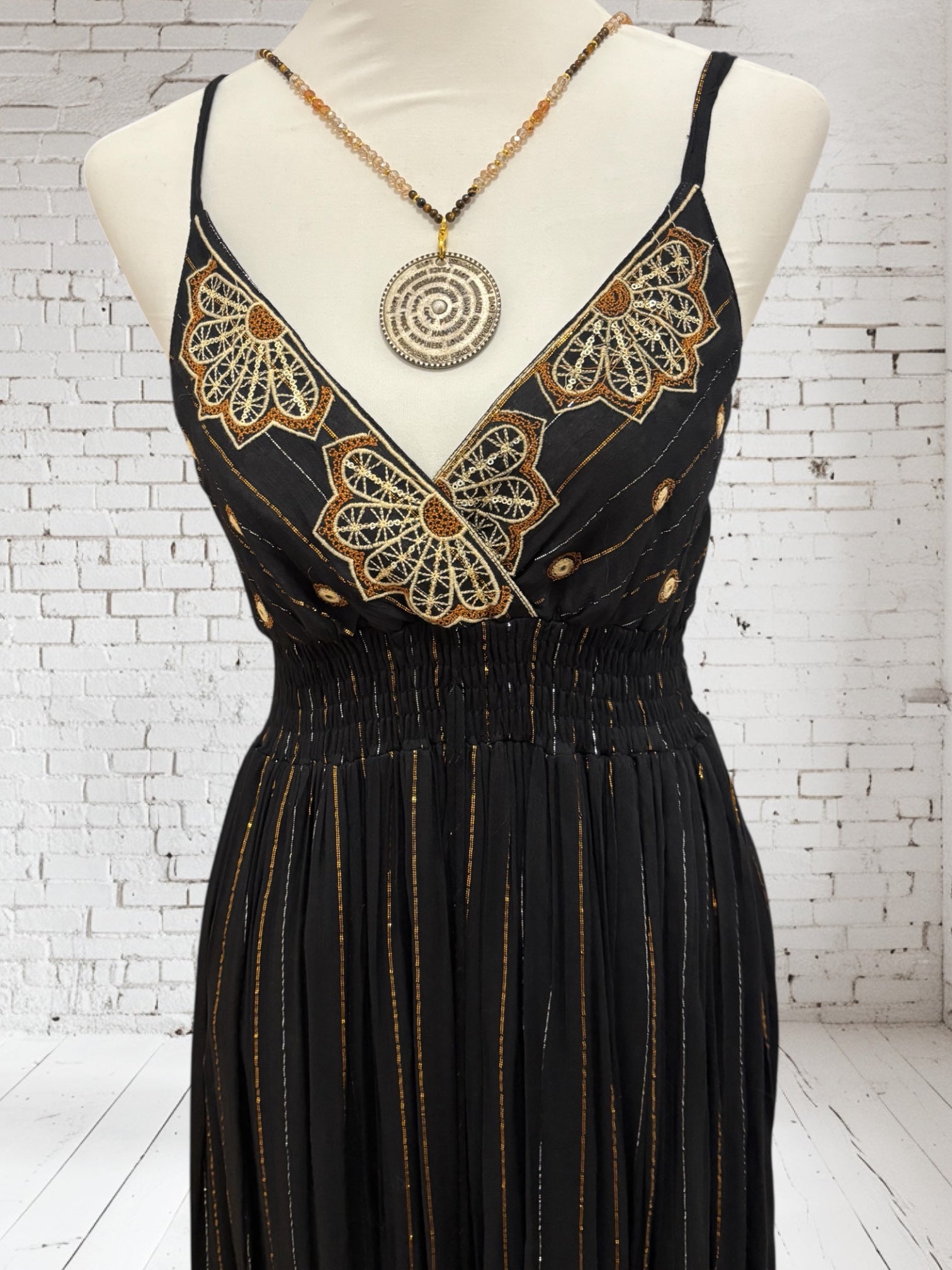 Casa-Petrada Nahaufnahme schwarzes Bohokleid mit goldenen Details.
