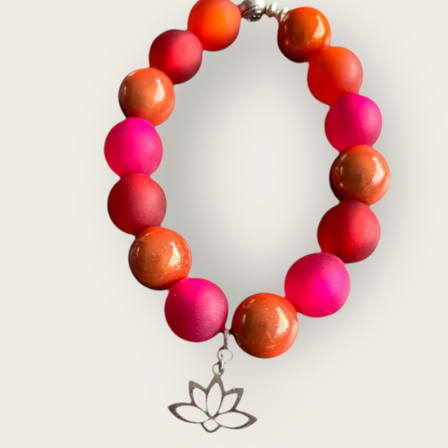 Armband RED DREAM aus roten und orangenen Perlen mit einem Anhänger Lotusblume