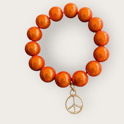 Armband aus Miracle Perlen in orange und einem Anhänger Peace