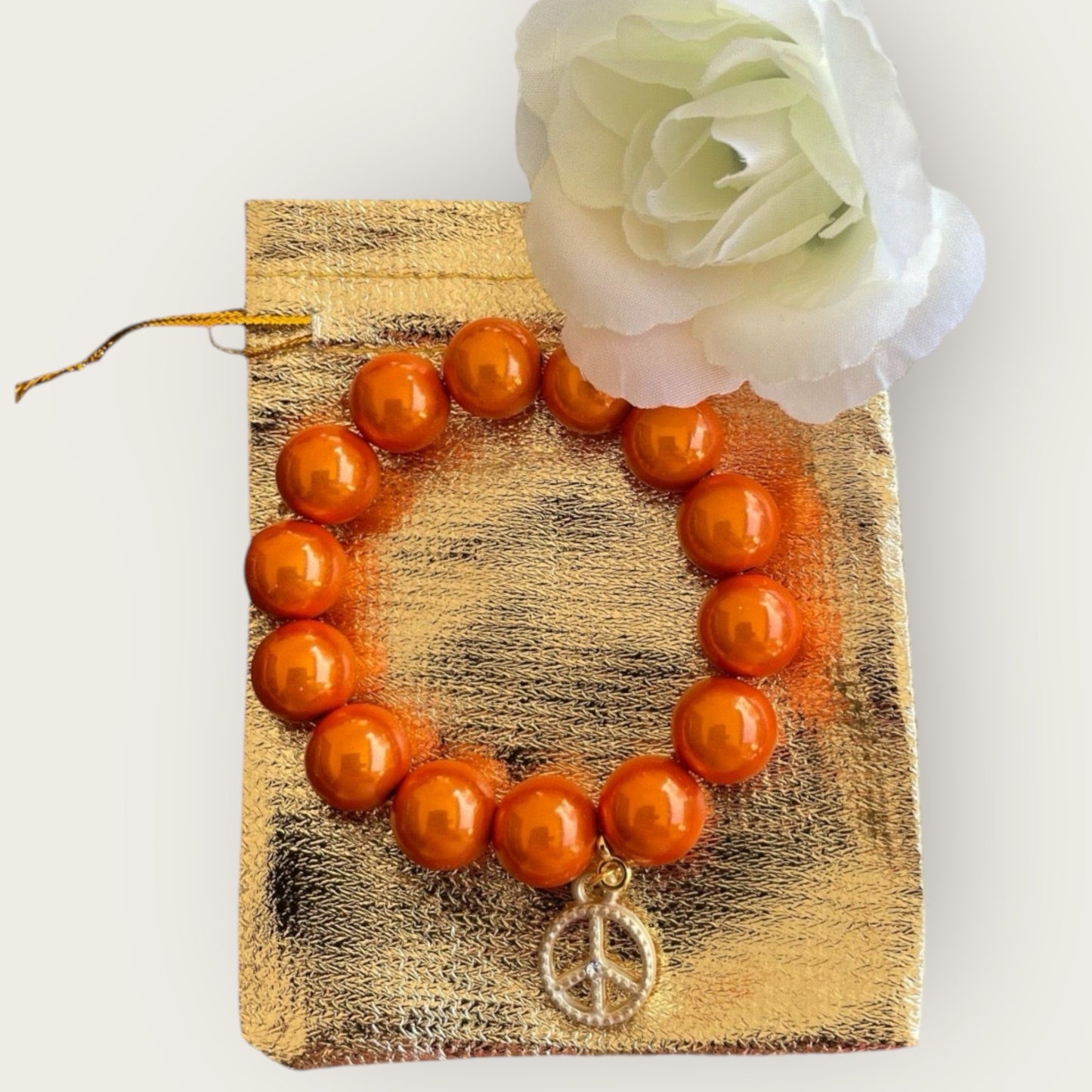 Armband aus Miracle Perlen in orange und einem Anhänger Peace