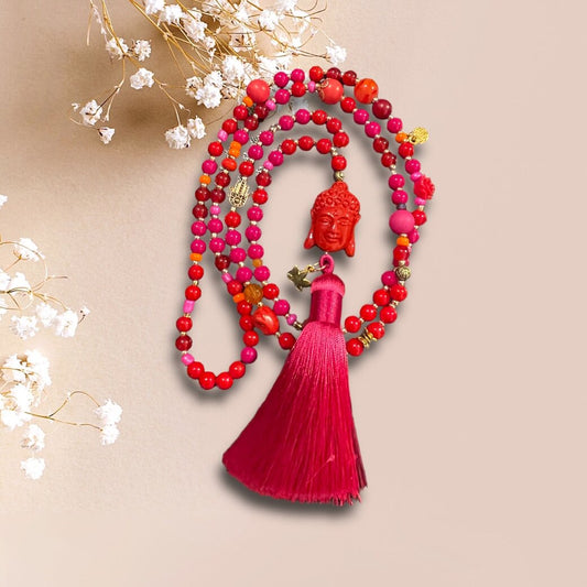 Kette aus leuchtenden Perlen in Rot und Pink mit einer Buddha Perle und einer Quaste in pink