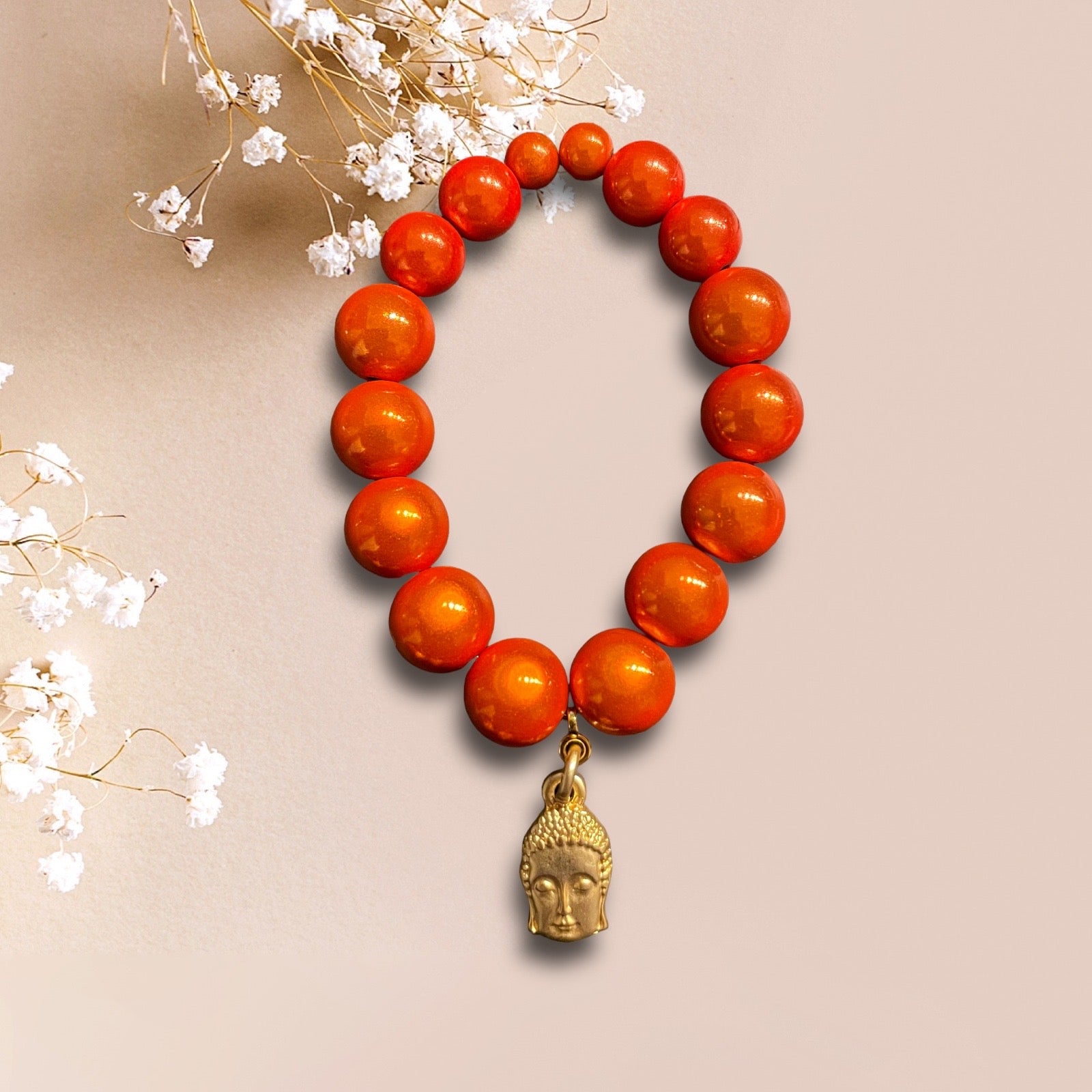 Armband aus großen Miracle Perlen in orange mit einem Anhänger Buddha