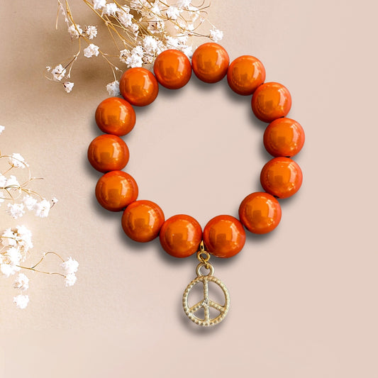Armband PEACEFUL WORLD aus Miracle Perlen in orange und einem Anhänger Peace der Marke Schautime